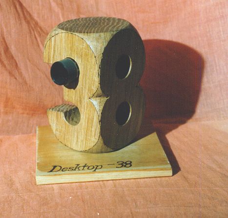 A wooden block sculptured to show figure 8 from one side and figure 3 from another side