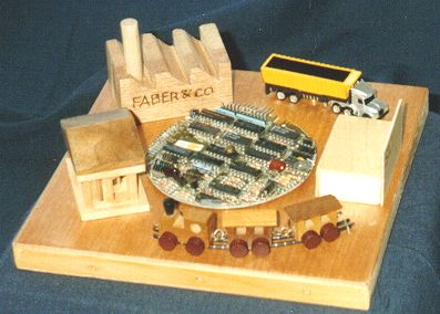 Model built with a round part of printed circuit board. Around this a 'consume temple', a bank, a train and a manufacturing plant is arranged.